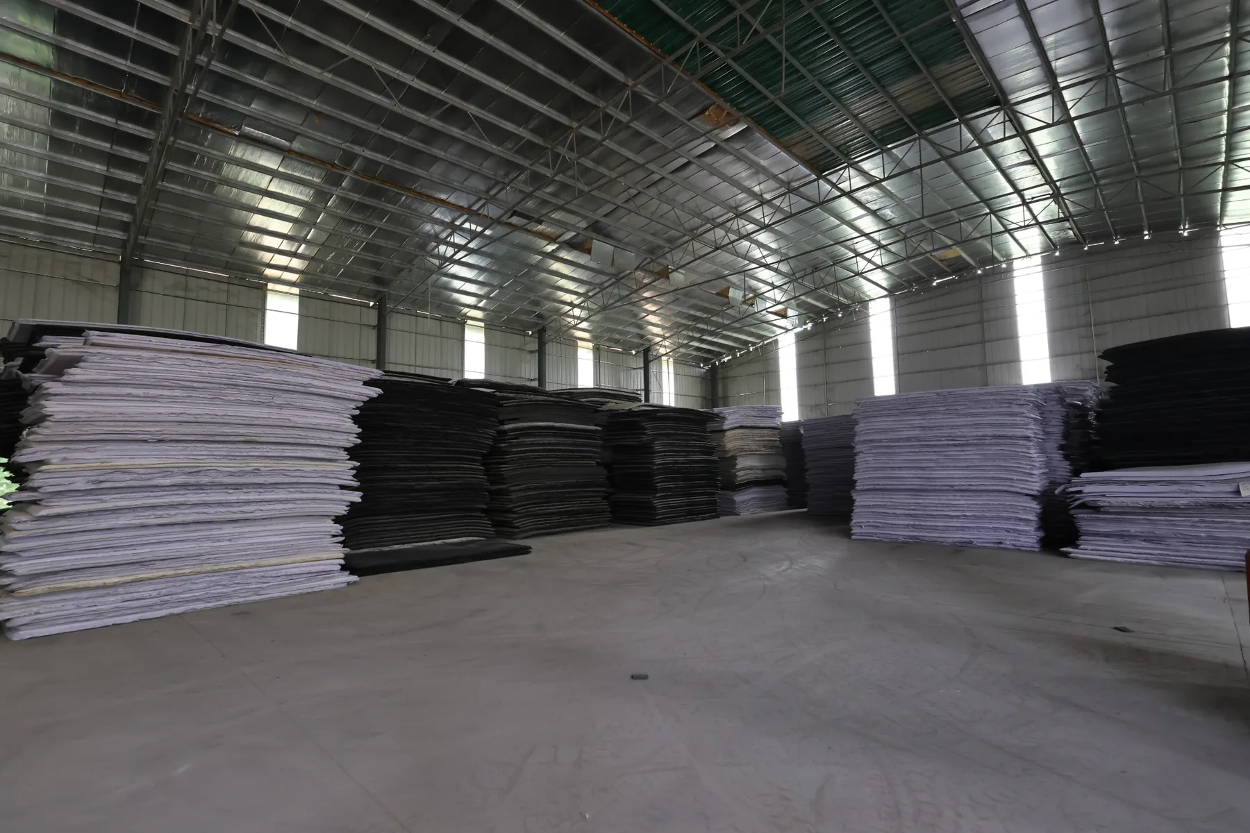EVA foam slab storage area with black and white sheet stacks